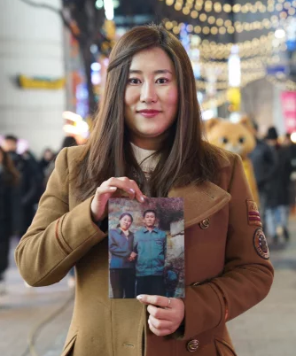 PHOTO: JACK PEARCE Jessie Kim, 27, holds the only photo she has with her late father, who never escaped North Korea.